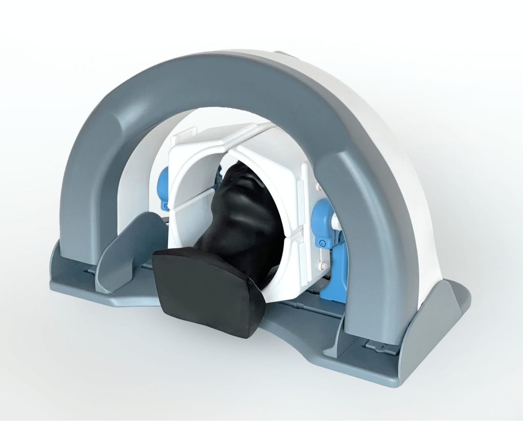 A photograph of a functional prototype of AiM Medical Robotics' MRI-compatible neurosurgical robot with a black mannequin head shown for scale.