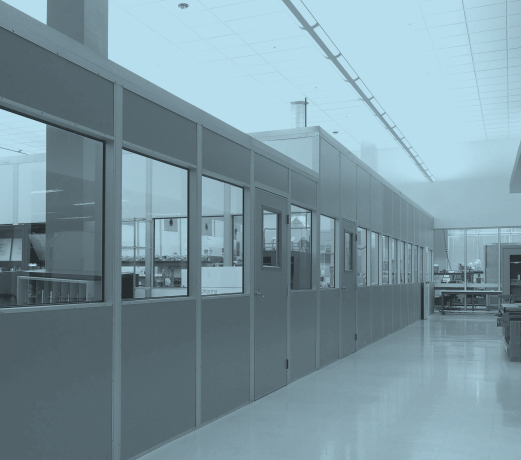 Monochromatic view of a modern office space with glass partitions.