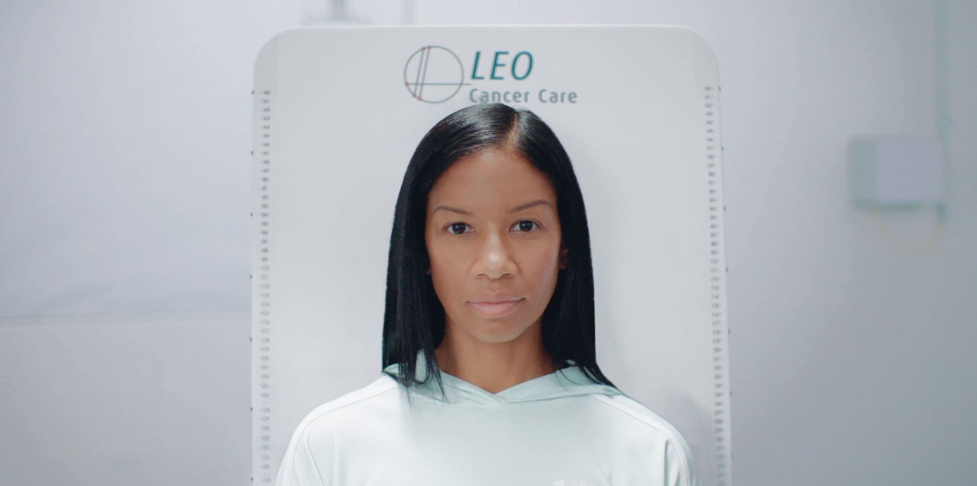 A woman undergoing a upright radiation therapy with Leo Cancer Care's system.