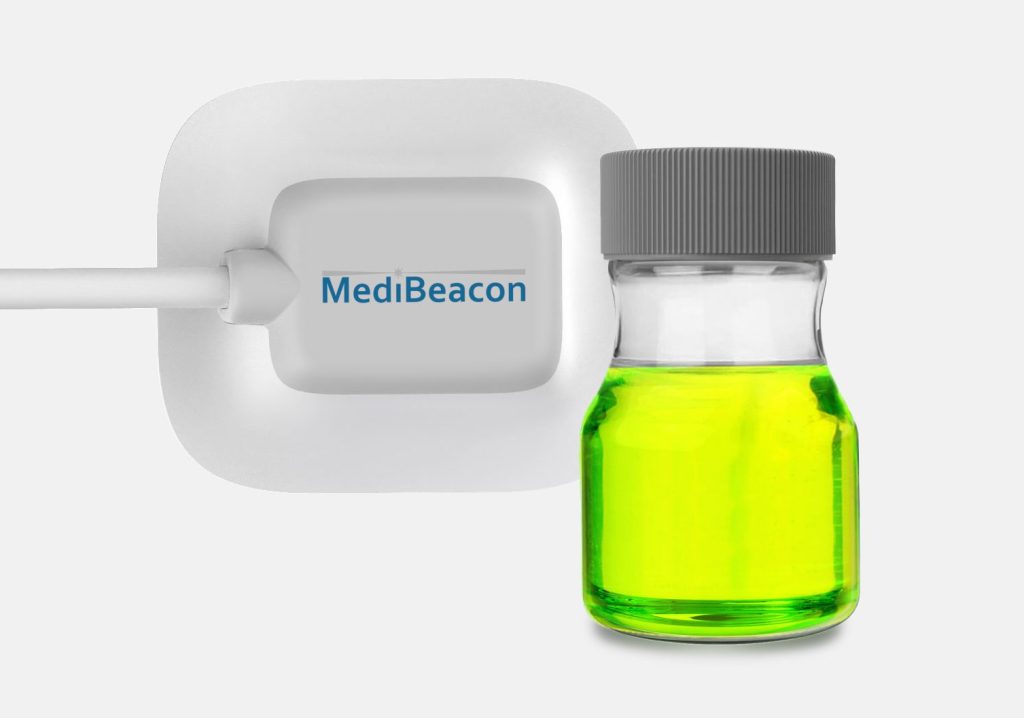 MediBeacon medical sensor device with branding next to a vial of green liquid.