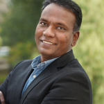 Professional man smiling at the camera with a natural background.