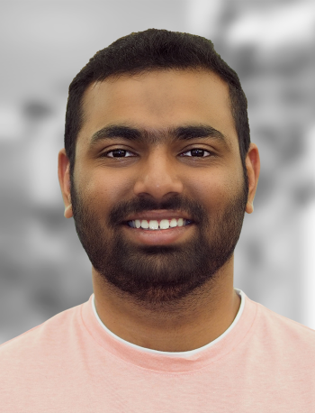 A portrait of Tanmay Kothale, a smiling man with a beard wearing a pink t-shirt against a blurred background.