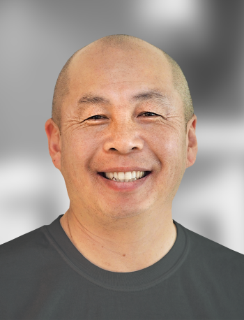 A portrait of Winston Sun, a smiling man with a gray background.